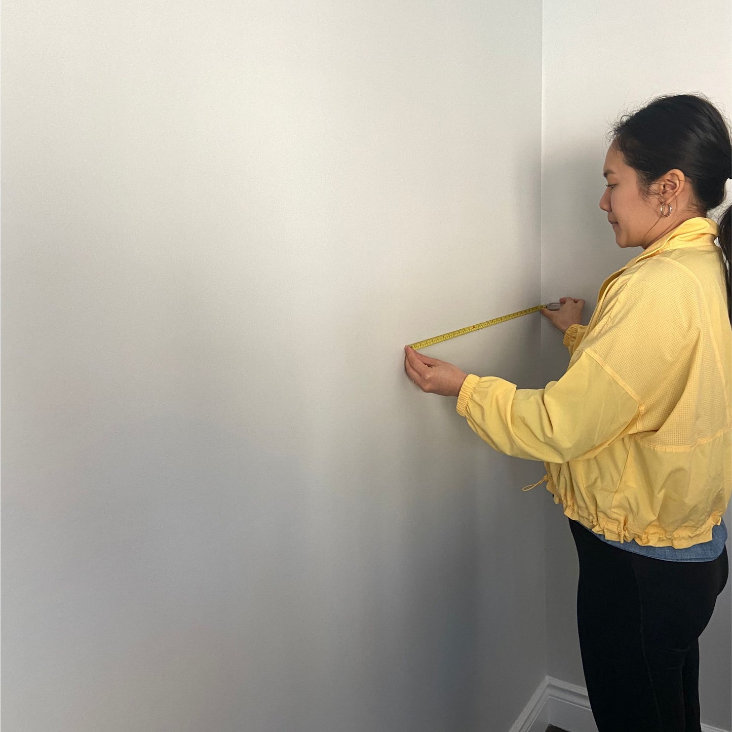 Hone co-founder Jennifer measuring a wall