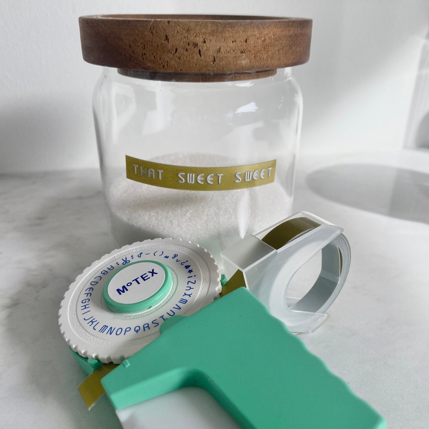 MoTEX refill tape in gold colour with the embossing labeller with a jar labelled