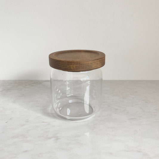 Small size glass canister with acacia wood lid pictured from the side