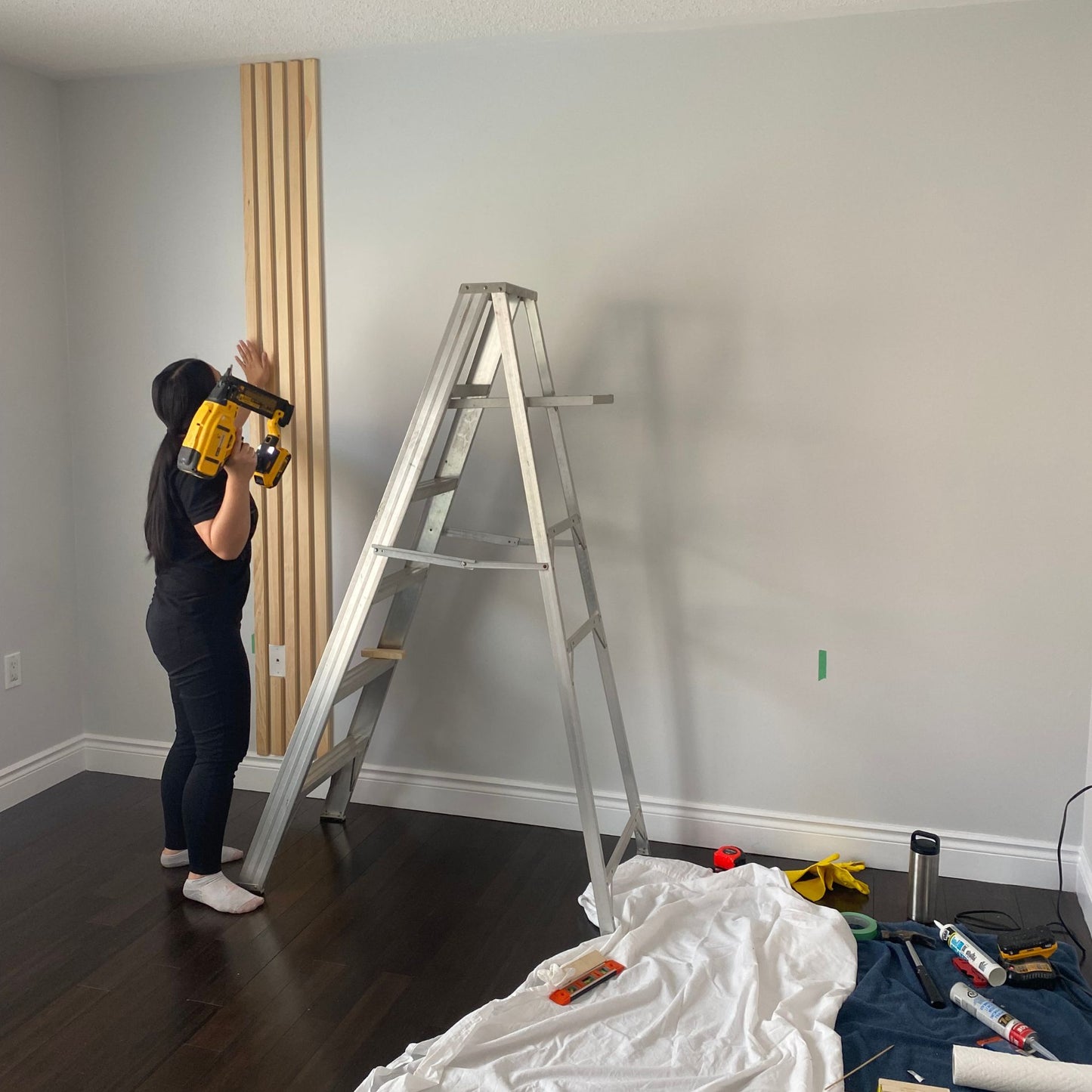 Nailing wood slats to wall for DIY accent wall